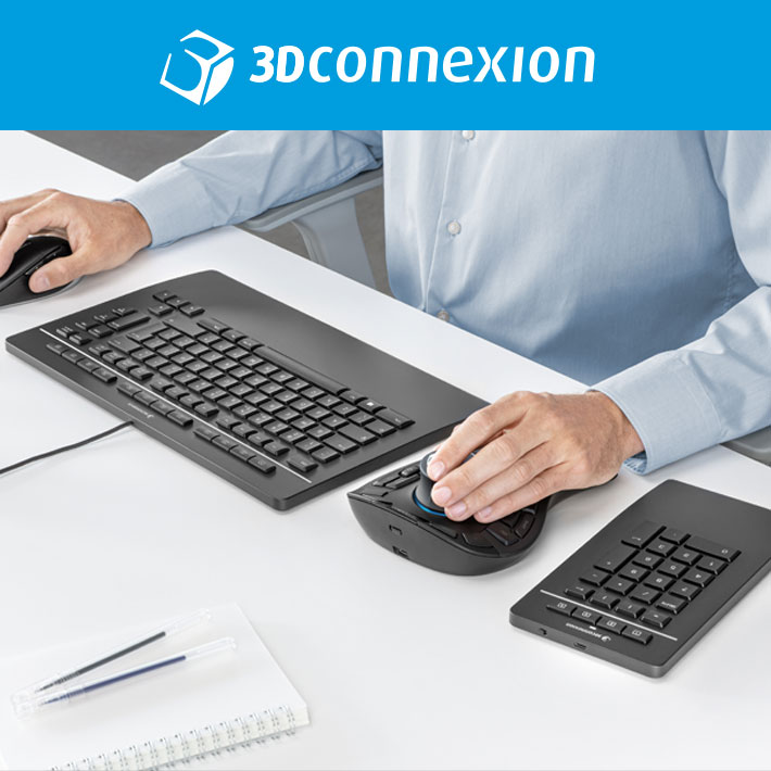 Een man zit aan een bureau en gebruikt een 3Dconnexion Keyboard Pro met Numpad